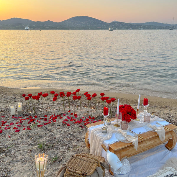 Scénographie romantique ( grandes roses piquées dans le sable, bougies led )