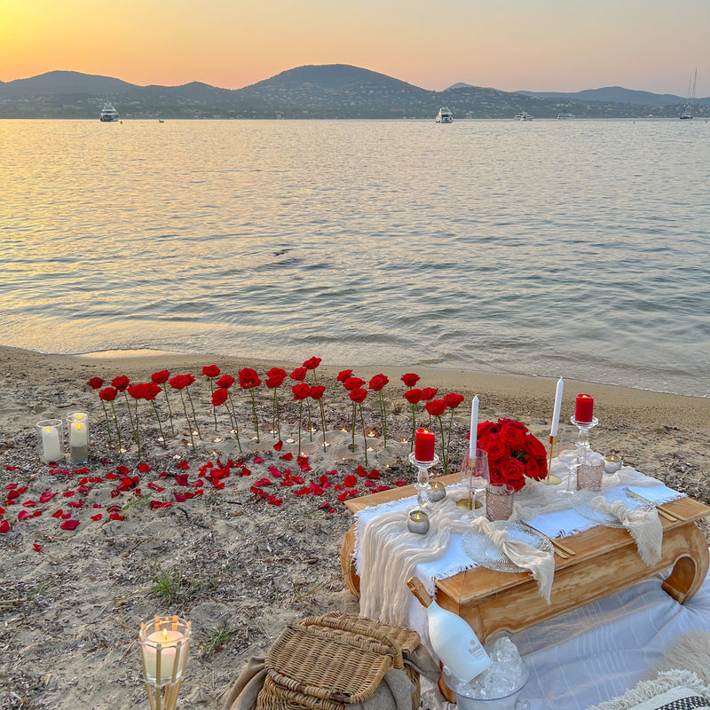 Scénographie romantique ( grandes roses piquées dans le sable, bougies led )